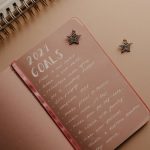 Top view of a 2021 goals notebook with handwritten list and star decorations, ideal for planning inspiration.